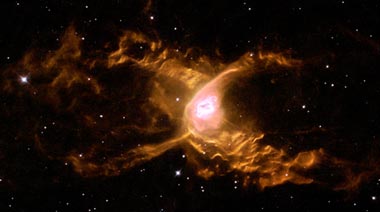 Ein anderer Planetarer Nebel, der "Rote Spinne" Nebel, wird von den stellaren Winden des Weißen Zwerges im Zentrum, wellenförmig verformt (Foto NASA und Hubble Heritage Team)